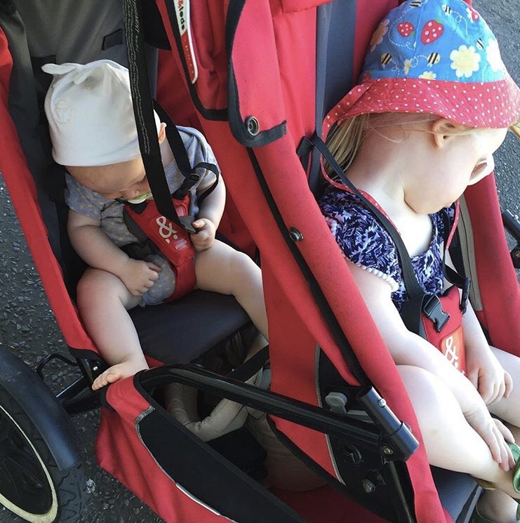 Two children sleeping in a double buggy