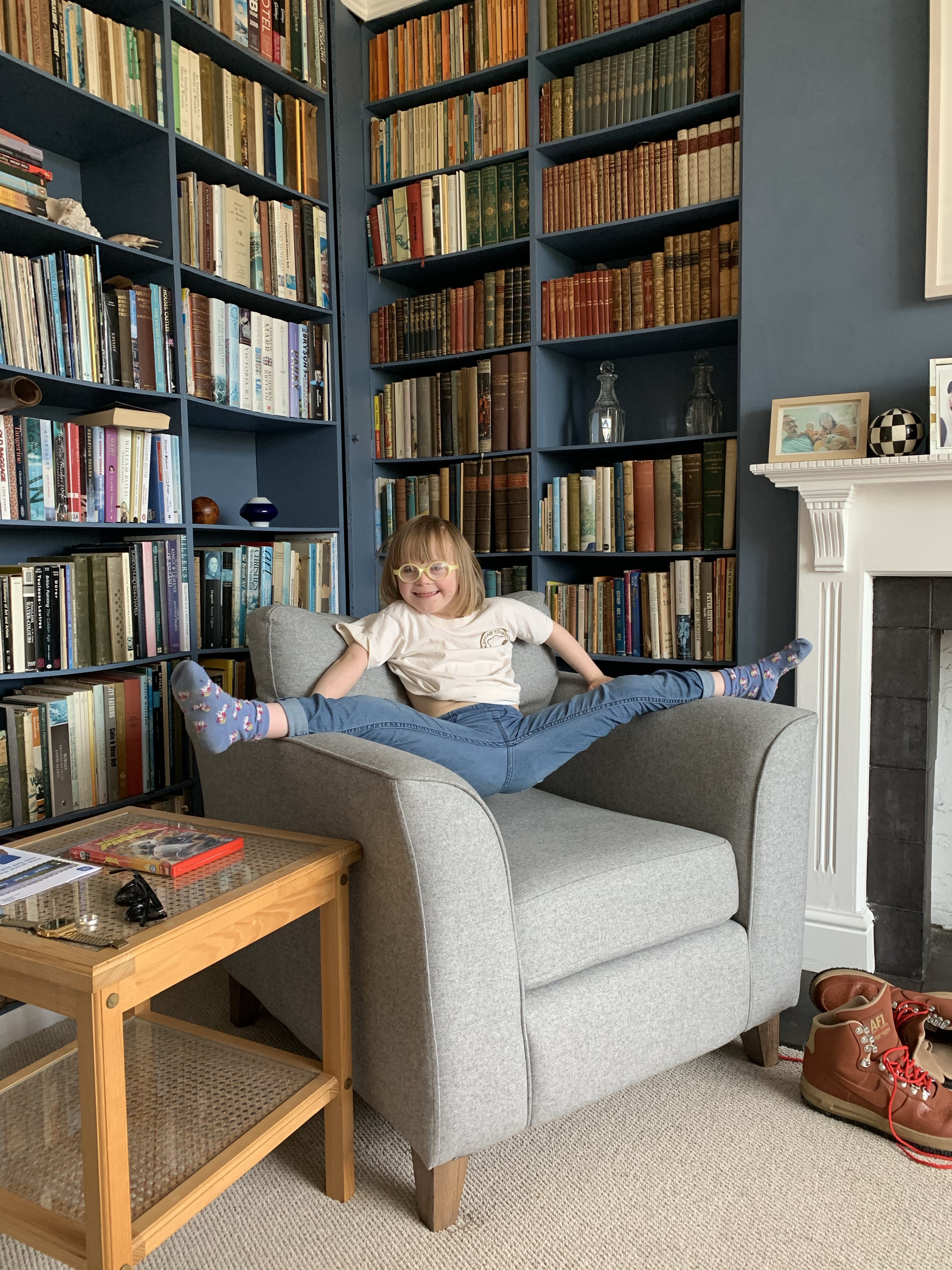 Little girl does the splits on an arm chair 